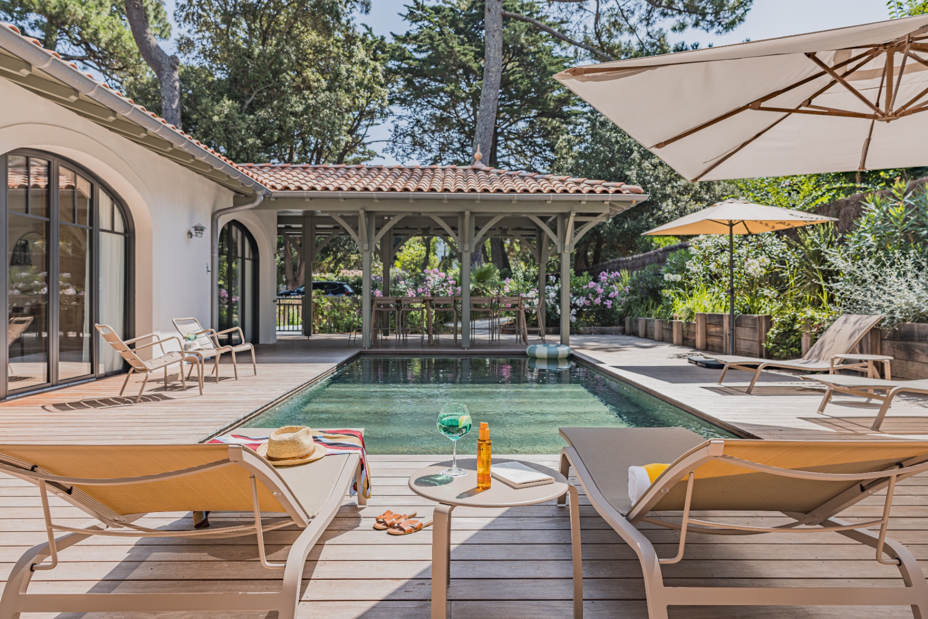 Terrasse en bois et piscine chauffée de la Villa La Perla face à l'océan